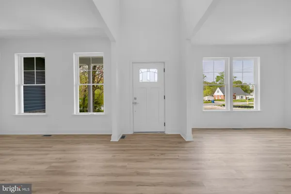 an empty room with window & wooden floor