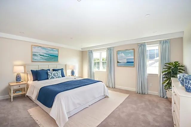 a bedroom with a large bed and a potted plant