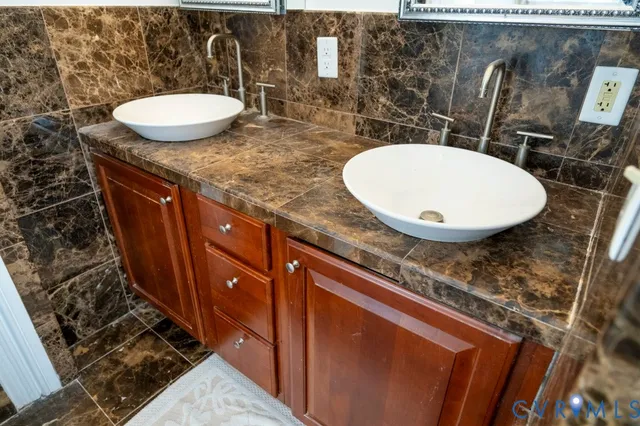 a bathroom with a granite countertop sink a mirror and vanity