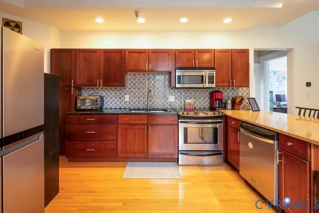 a kitchen with stainless steel appliances wooden cabinets and a sink