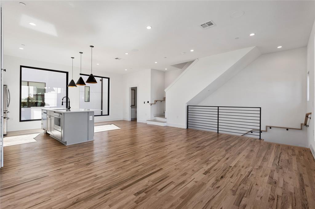 a view of empty room with wooden floor and window