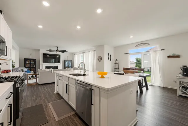 a view of a kitchen with cabinets stainless steel appliances and a dining table