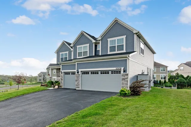 a front view of a house with a garden and trees