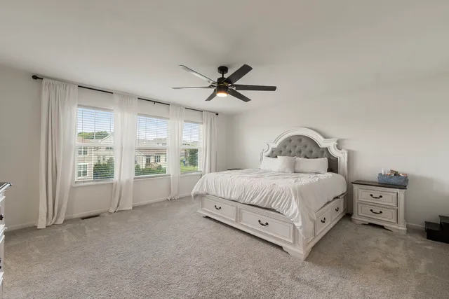 a spacious bedroom with a bed and a large window