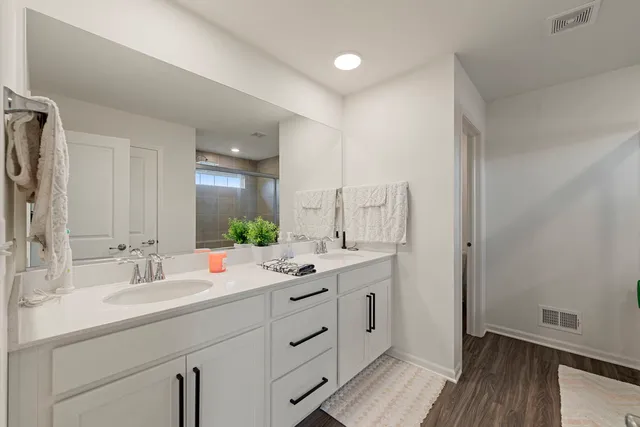 a bathroom with a double vanity sink mirror and