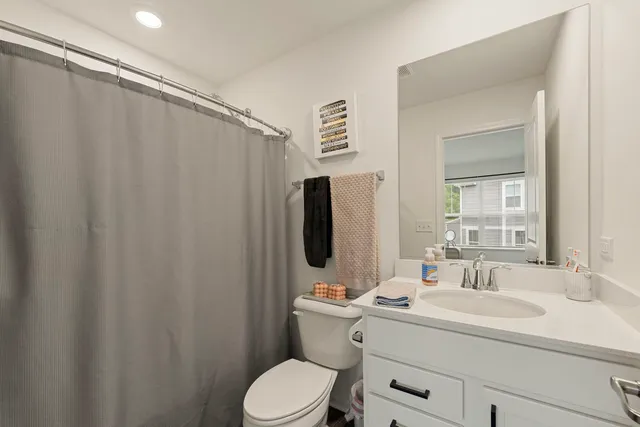 a bathroom with a sink vanity mirror and toilet