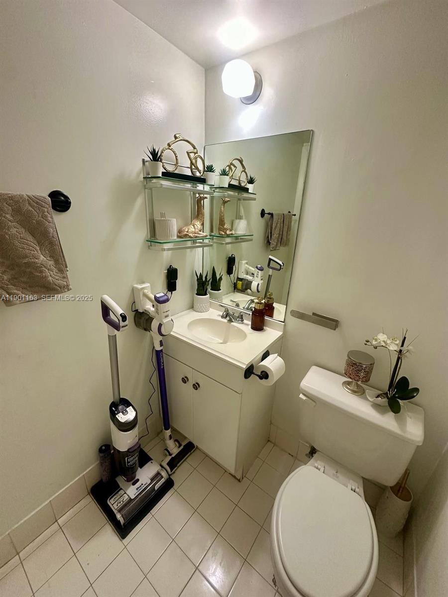 12306 Northwest 11th Street, Unit 1404 Miami, FL 33182 - Photo 23 of 31 a bathroom with a toilet sink and mirror