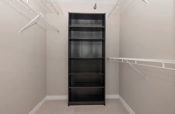 a view of walk in closet with empty racks
