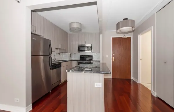 a kitchen with stainless steel appliances a refrigerator a stove top oven a sink and dishwasher