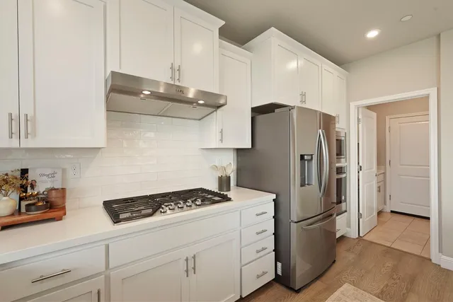 a kitchen with appliances a refrigerator and cabinets