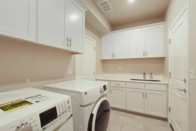 a utility room with sink dryer and washer