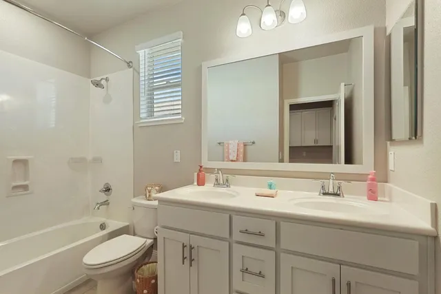 a bathroom with a granite countertop toilet sink and a mirror
