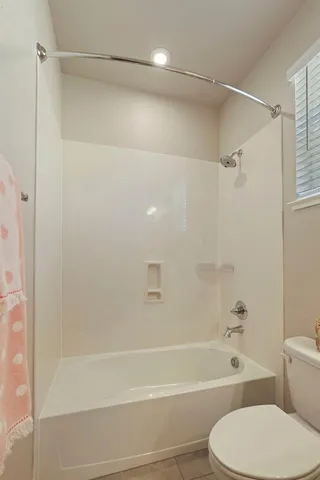 a bathroom with a toilet and a bath tub