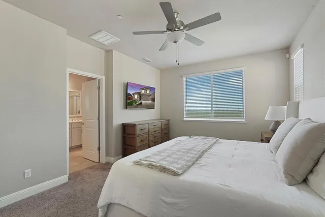 a bedroom with a large bed and a chandelier