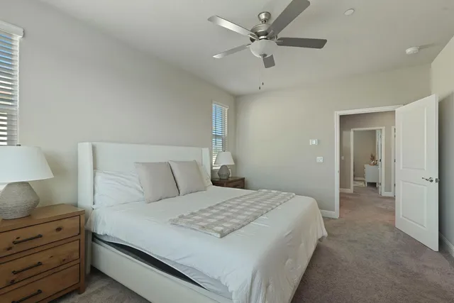 a bedroom with a bed and a lamp on dresser