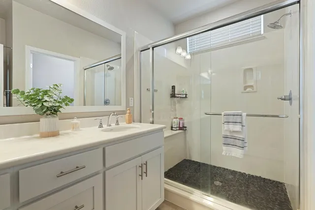 a bathroom with a shower sink and mirror