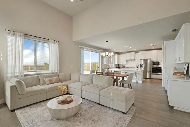 a living room with furniture and a view of kitchen