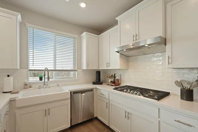 a kitchen with cabinets appliances a sink and a window