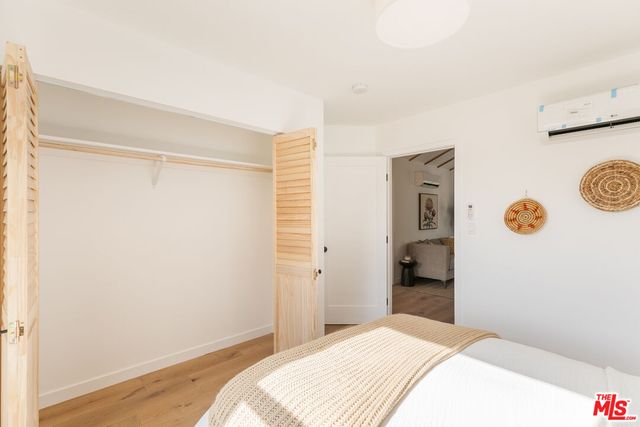 a bedroom with a bed and a refrigerator