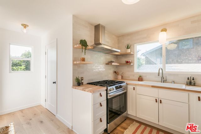 a kitchen with stainless steel appliances a sink stove and cabinets