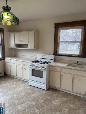 a kitchen with white cabinets and white appliances