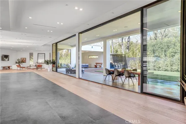 a dining room with furniture large windows and wooden floor