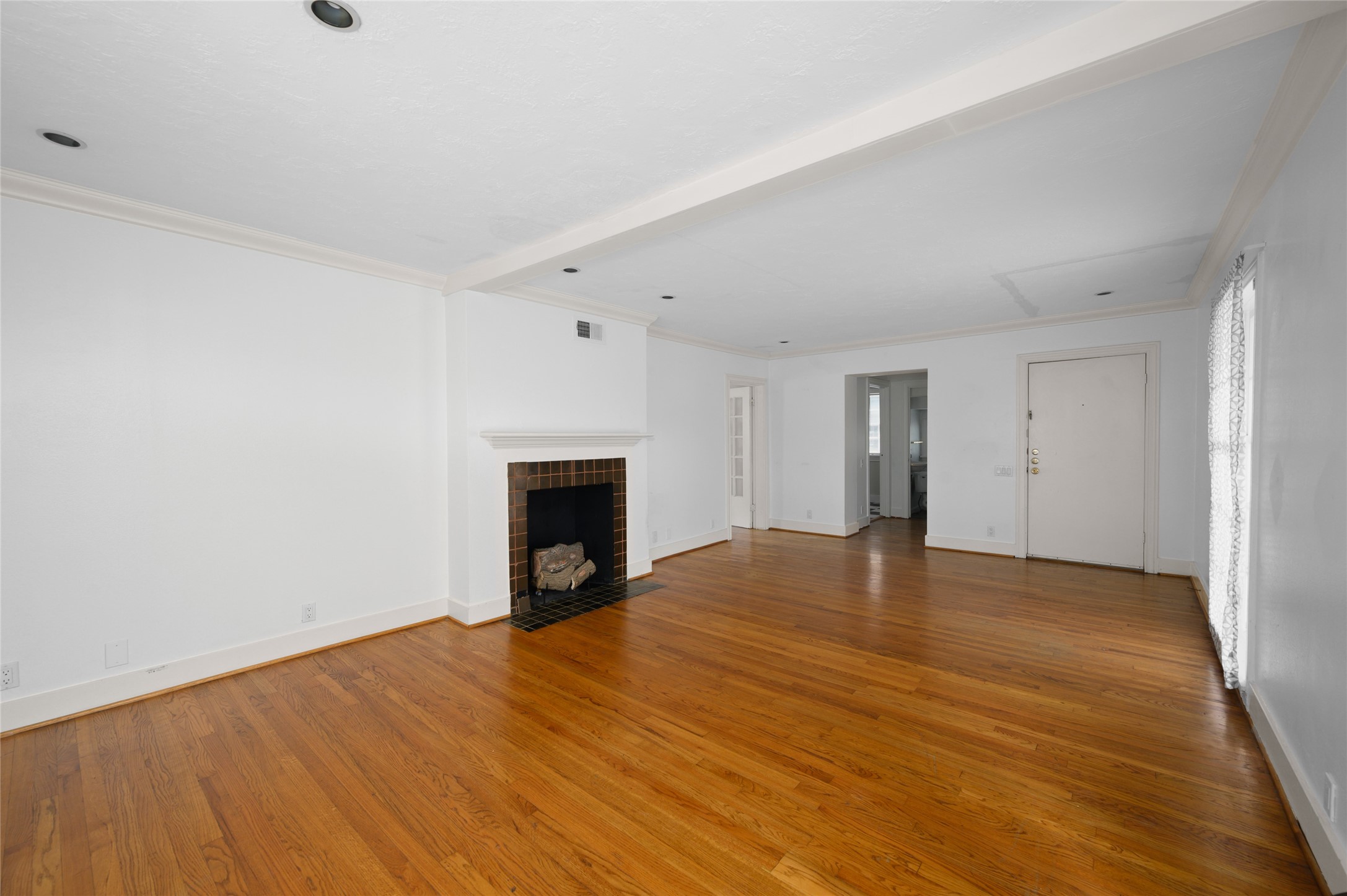 1955 Lexington Street, Unit A Houston, TX 77098 - Photo 3 of 12 a view of empty room with wooden floor and fireplace
