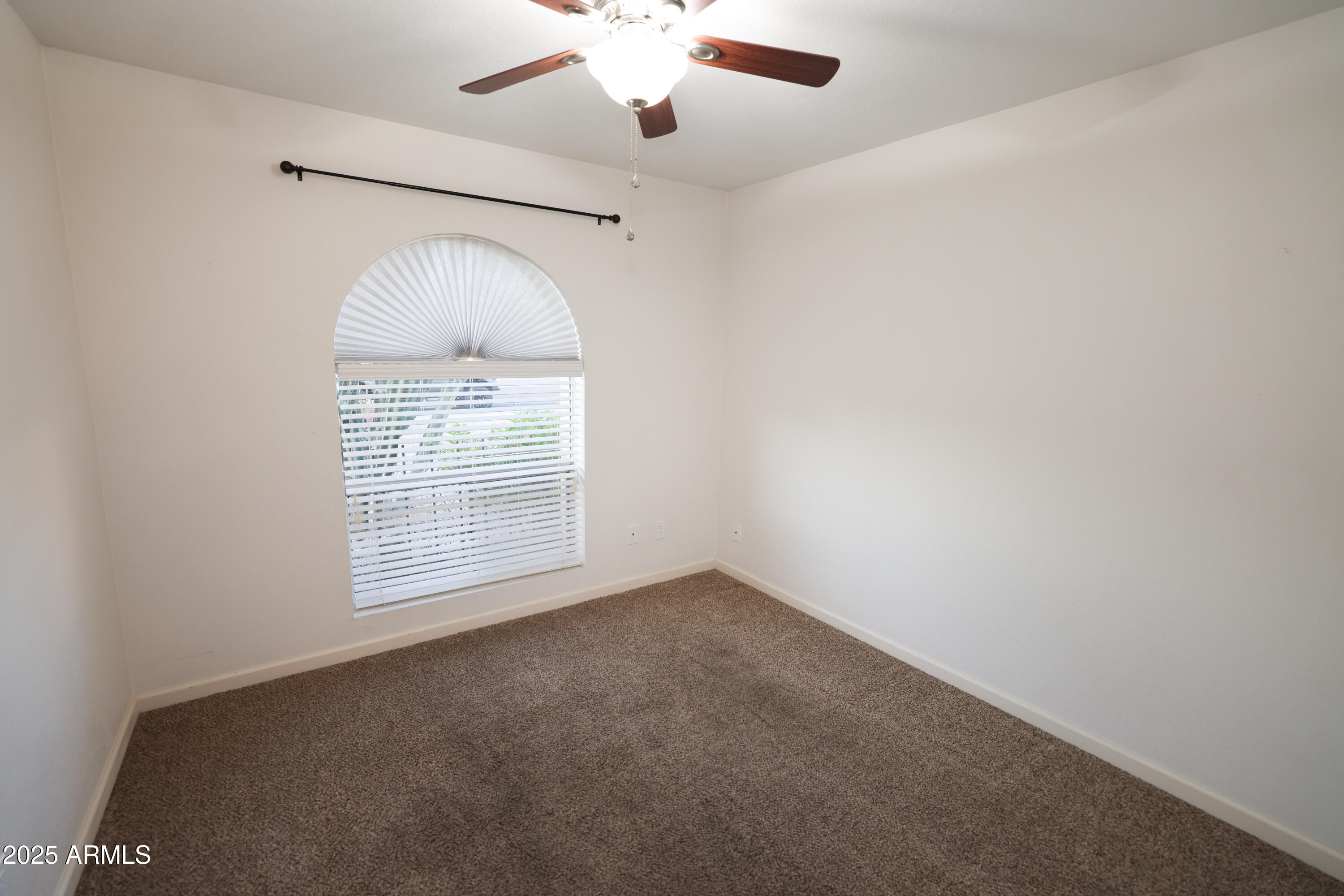 4841 West Mercer Lane Glendale, AZ 85304 - Photo 12 of 15 an empty room with a window and a fan