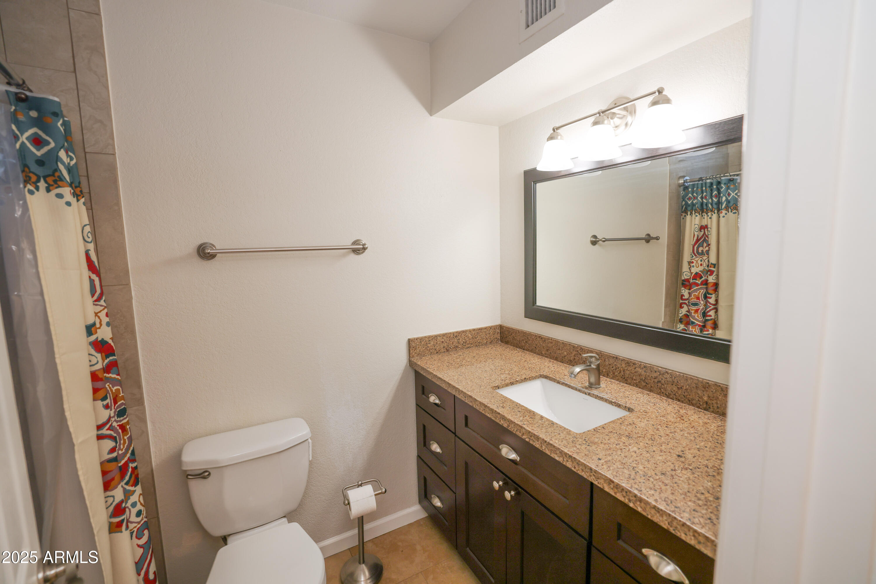 4841 West Mercer Lane Glendale, AZ 85304 - Photo 13 of 15 a bathroom with a granite countertop sink toilet and shower