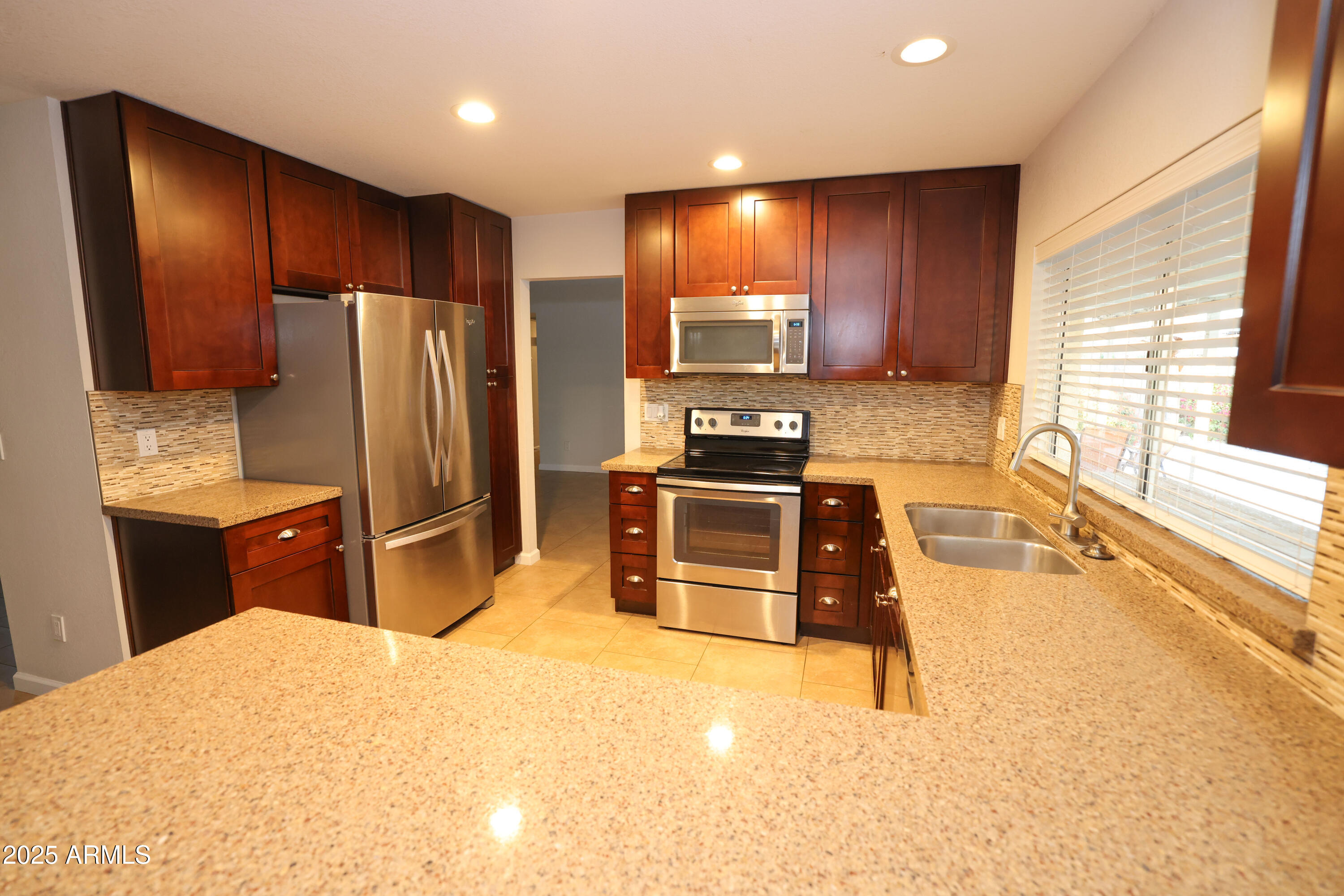 4841 West Mercer Lane Glendale, AZ 85304 - Photo 7 of 15 a kitchen with stainless steel appliances a stove a refrigerator and a sink