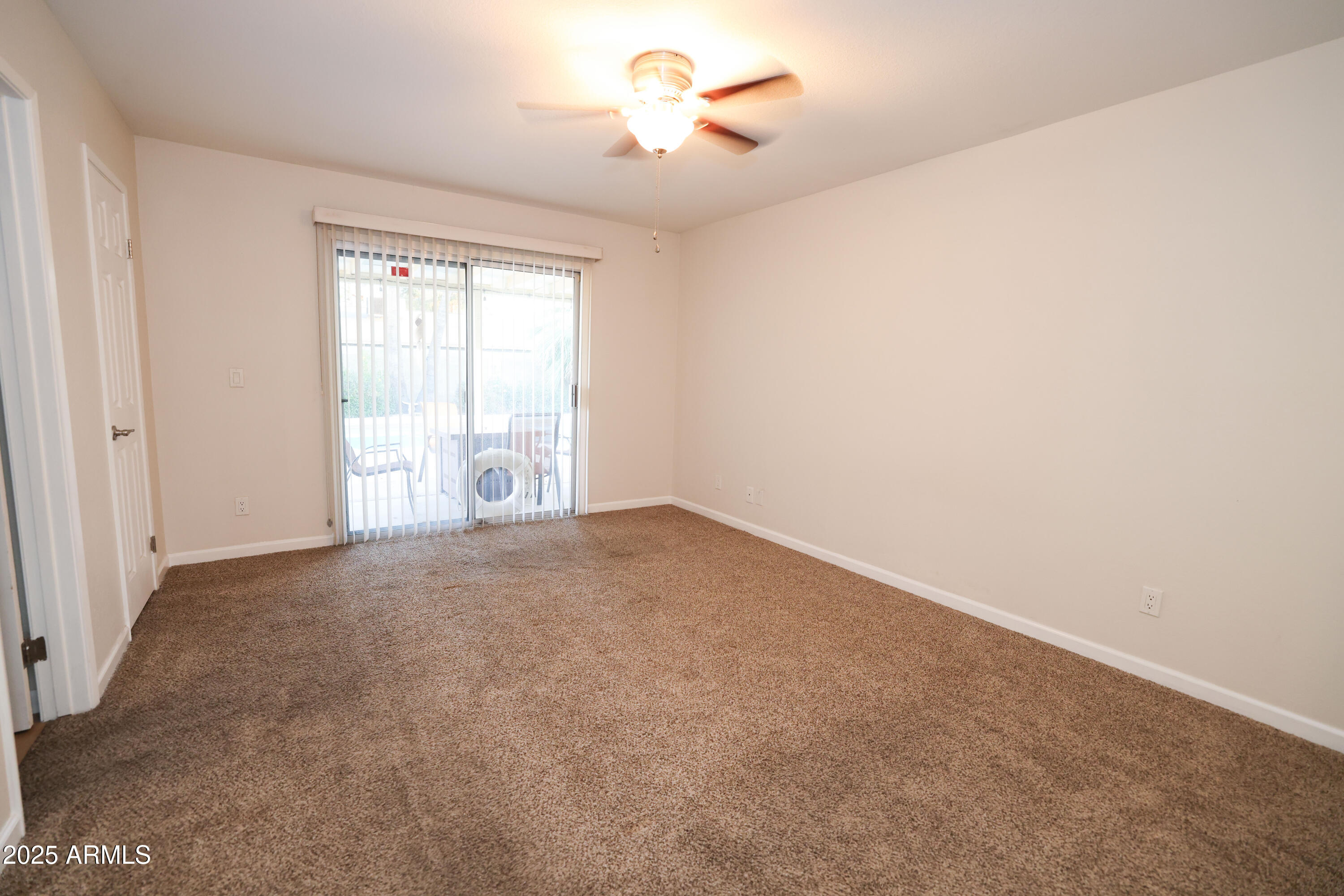 4841 West Mercer Lane Glendale, AZ 85304 - Photo 8 of 15 an empty room with chandelier fan and windows