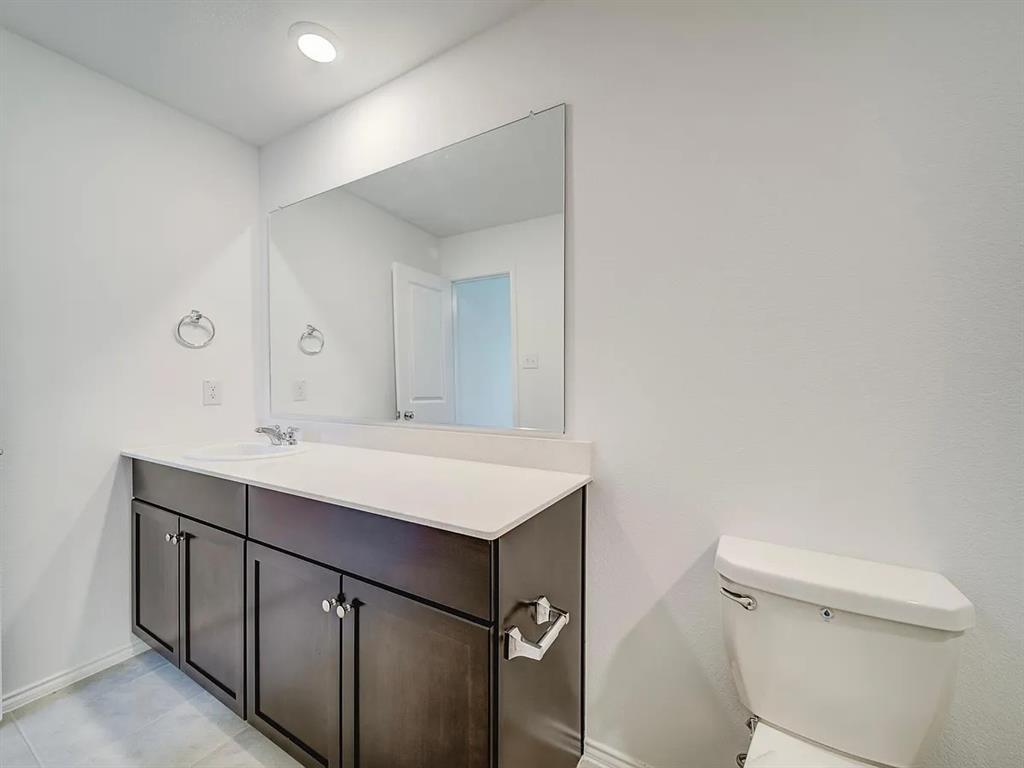 352 Sun Bluff Road Fort Worth, TX 76052 - Photo 16 of 33 Bathroom featuring a single vanity with a white countertop, dark wood-finish cabinetry, an integrated sink with a chrome faucet, and a large wall-mounted mirror
