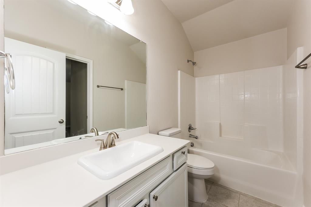 9430 Smoke Tree Drive Forney, TX 75126 - Photo 14 of 17 a bathroom with a granite countertop sink a toilet and shower