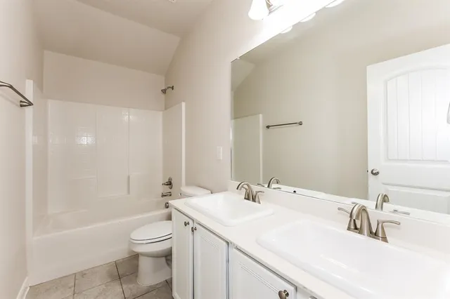 a bathroom with a sink a toilet a tub and a mirror