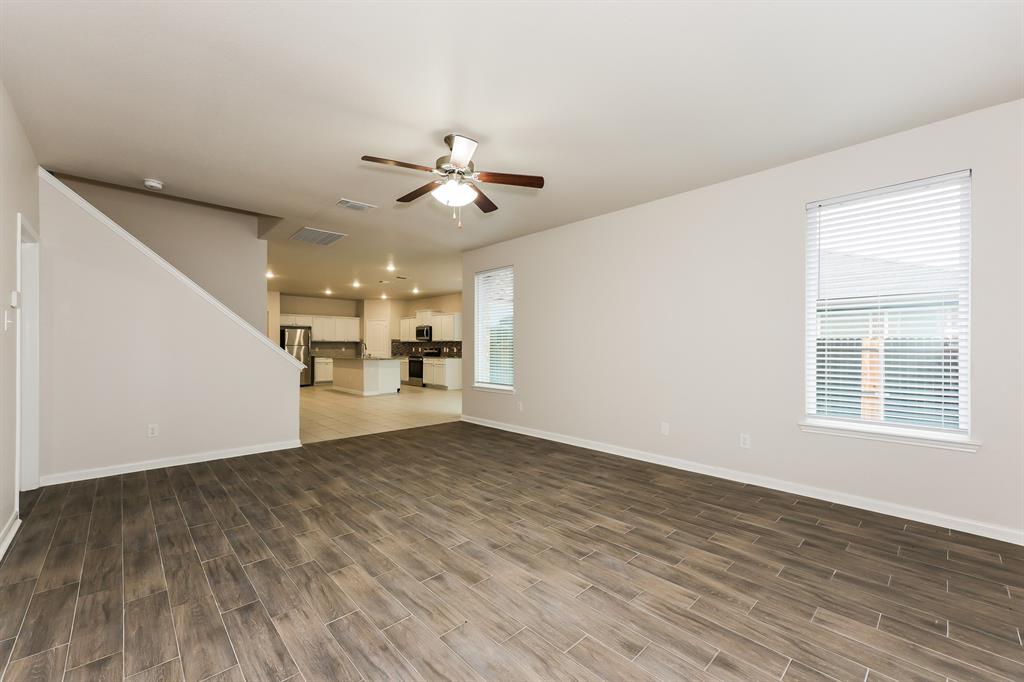 9430 Smoke Tree Drive Forney, TX 75126 - Photo 3 of 17 a view of a livingroom with a kitchen stove a microwave and wooden floor