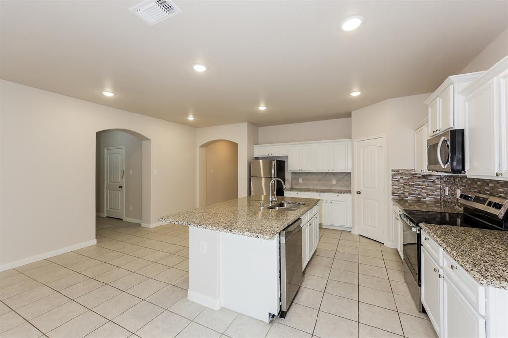 9430 Smoke Tree Drive Forney, TX 75126 - Photo 5 of 17 a kitchen with stainless steel appliances granite countertop a stove and a sink