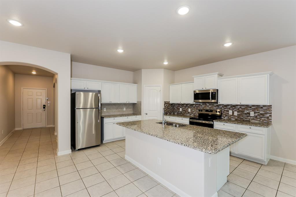 9430 Smoke Tree Drive Forney, TX 75126 - Photo 6 of 17 a kitchen with stainless steel appliances granite countertop a sink stove and refrigerator
