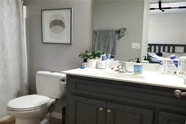 a hallway with a view of living room with a wooden floor