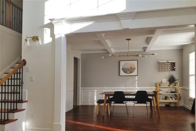 a dining room with furniture wooden floor a rug and a chandelier