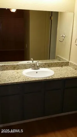 a bathroom with a granite countertop sink