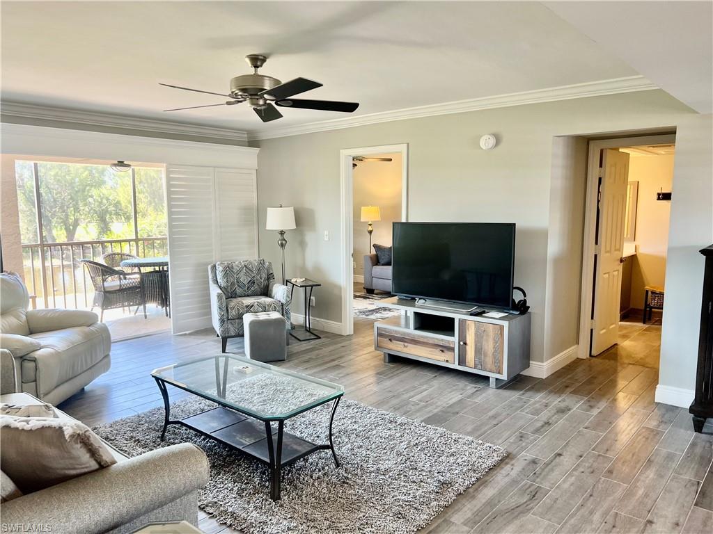 1790 Imperial Golf Course Boulevard, Unit A205 Naples, FL 34110 - Photo 5 of 28 a living room with furniture and a flat screen tv