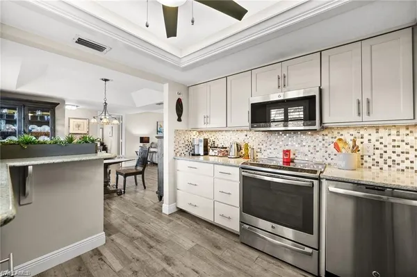 a kitchen with granite countertop white cabinets and white appliances