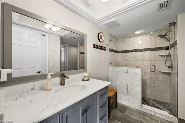 a bathroom with a granite countertop sink mirror and shower