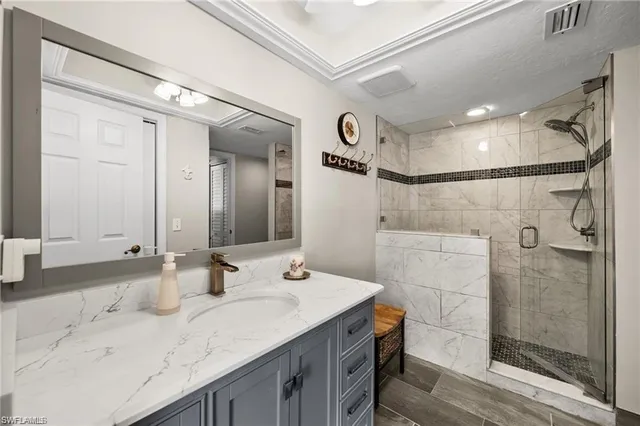 a bathroom with a granite countertop sink mirror and shower