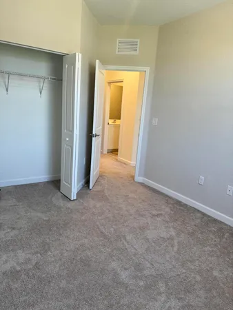 an empty room with closet and a bathroom