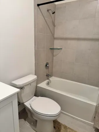 a white toilet and tub sitting next to a bathroom sink