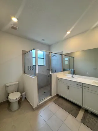 a spacious bathroom with a toilet sink and mirror