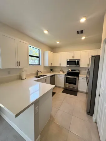 a kitchen with stainless steel appliances a refrigerator sink stove microwave and cabinets