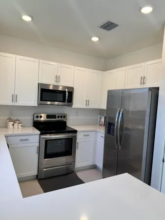 a kitchen with stainless steel appliances a refrigerator a stove a microwave and cabinets