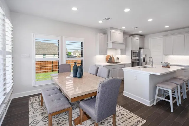 a kitchen with a dining table chairs and window